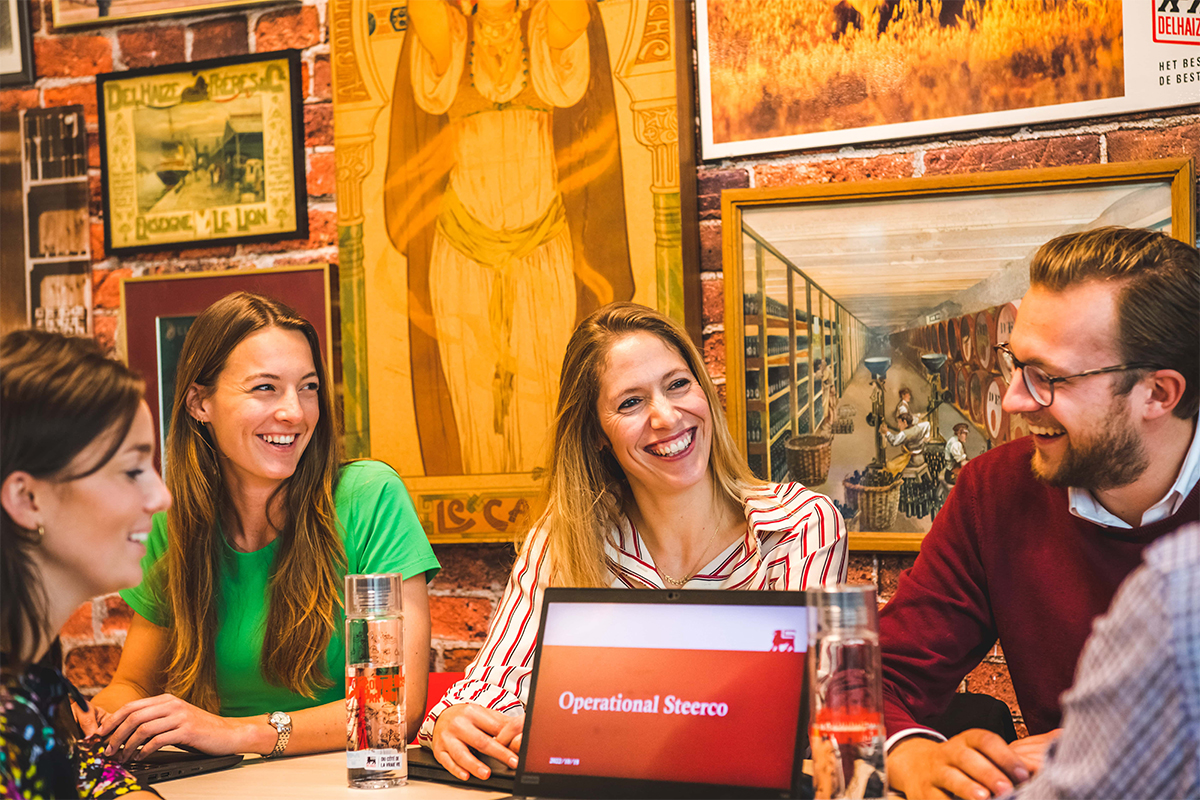 AholdDelhaize_Careers_Delhaize Belgium_Valerie Fabri_Supply Chain_talking_colleagues_laughing_laptop.jpg